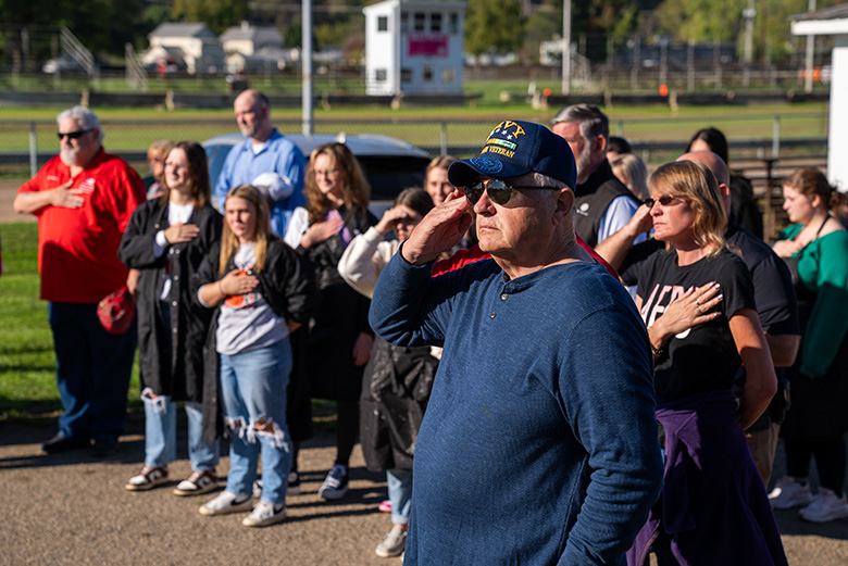 Athens Area Stand Down staff, volunteers and community members stand for the national anthem during the opening ceremony.