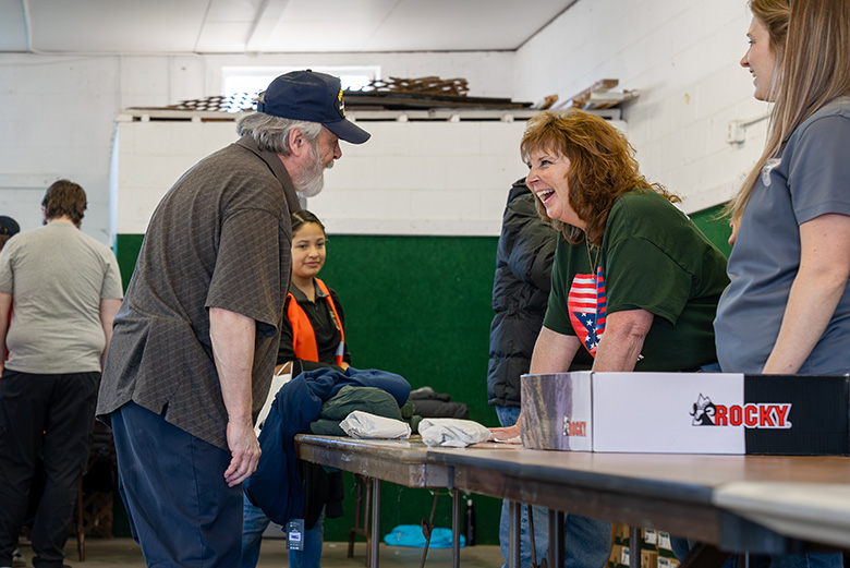 A veteran talks with a Stand Down volunteer as he is provided with clothing and other essential items.