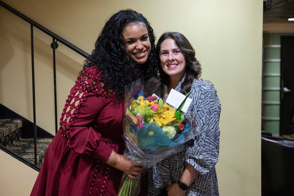 Hadiya Ray posing with her advisor Liz Pahl, holding flowers