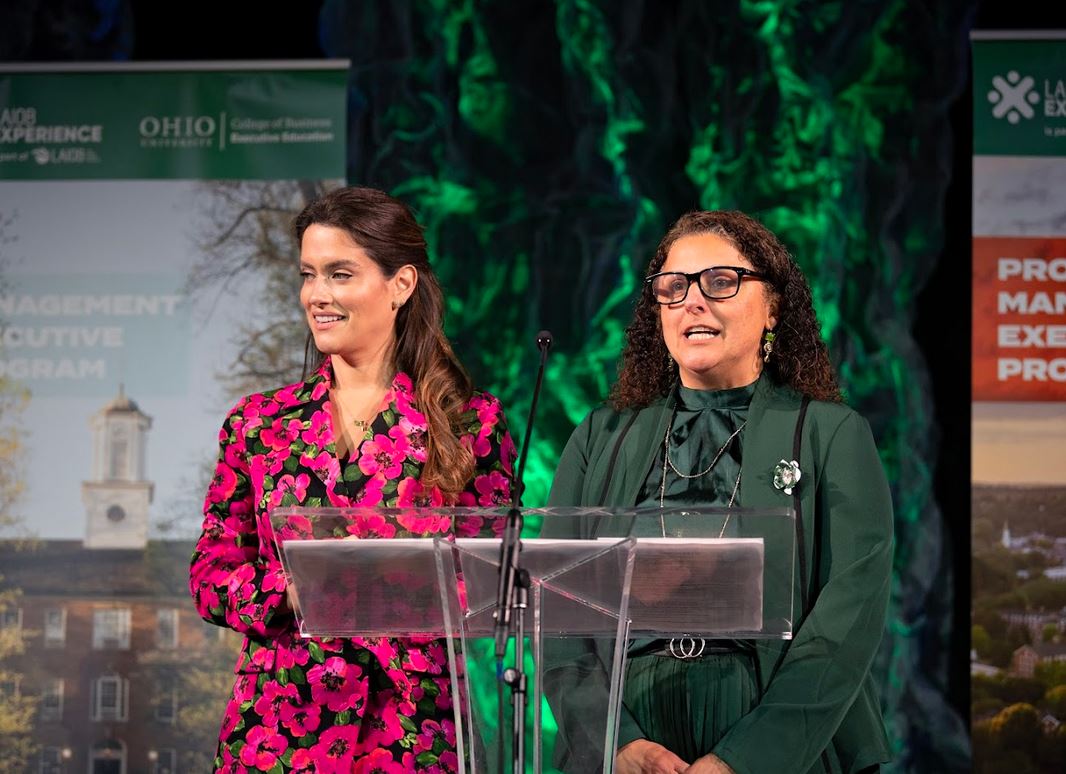 Two women speaking at a podium. 