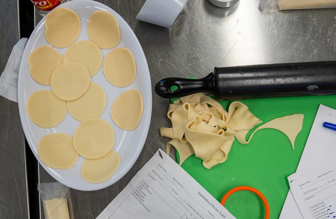 A pan with dough and scraps on the counter beside it