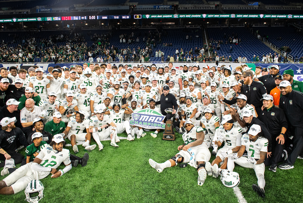 The OHIO Bobcat football team poses with the 2024 MAC Championship trophy