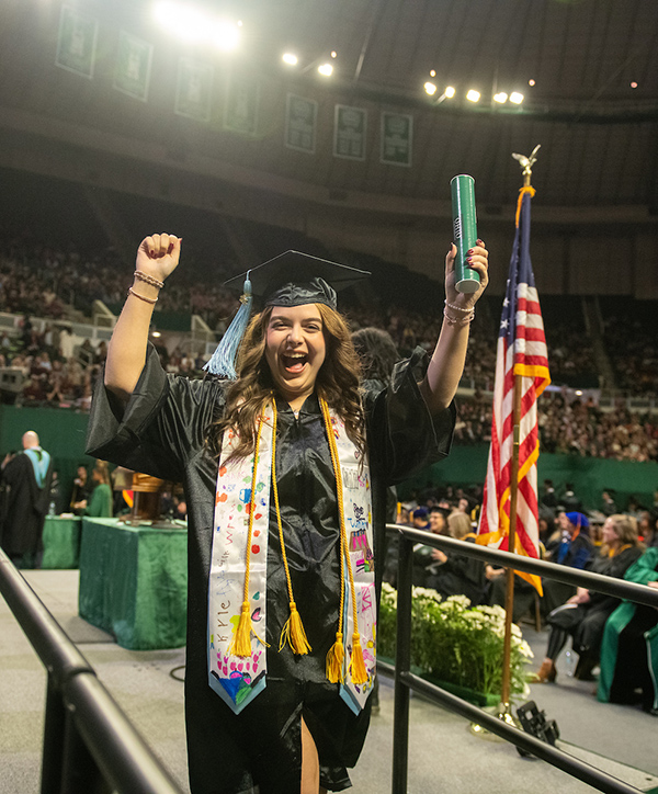 A proud graduate walks off the stage at the Fall 2024 commencement ceremony