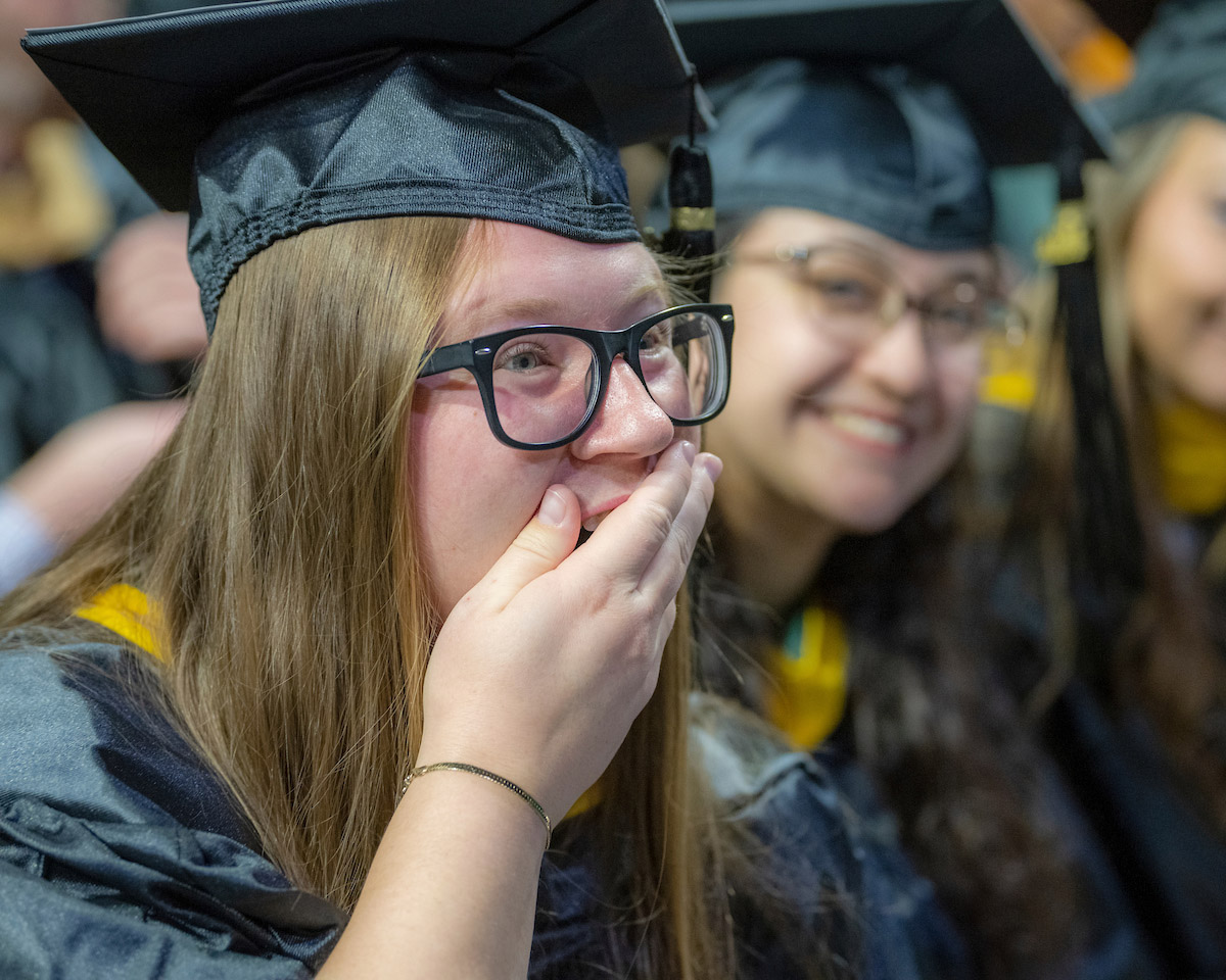 A female grad reacts in surprise during the Fall 2024 commencement ceremony