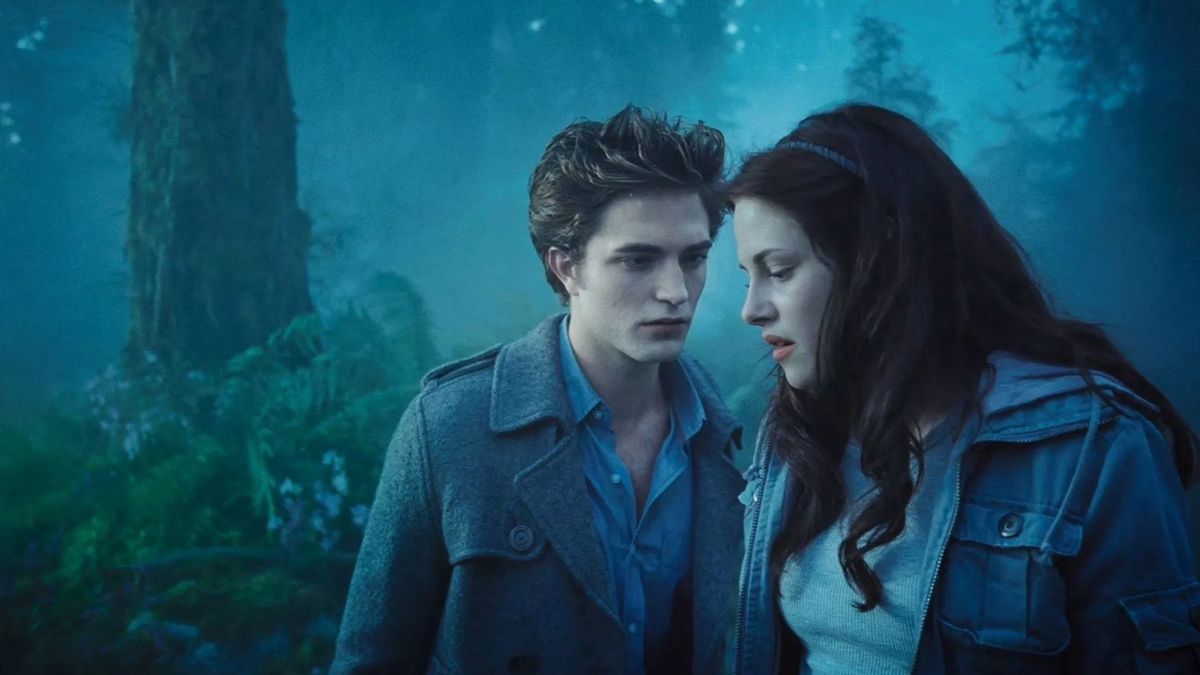 Bella Swan and Edward Cullen from the movie Twilight standing close together in a misty forest.