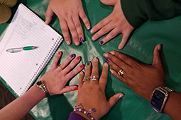 A volunteer paints ring fingers purple in support of the #PutTheNailInIt campaign to end domestic violence.