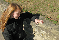 Nora Sheridan stands by a carving her great-grandfather made.