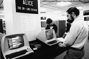 Ohio University Libraries employee Steven Cohen stands at a terminal in Alden Library, using the new online catalog system, ALICE, in this 1983 photo.