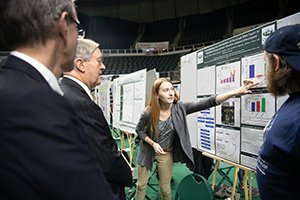 Emily Trzeciak presents her research to (from left) then-Vice President for Research and Creative Activity and Dean of the Graduate College and current Interim Dean of the College of Arts and Sciences Joe Shields and Ohio University President M. Duane Nellis at the 2018 Student Research and Creative Activity Expo.