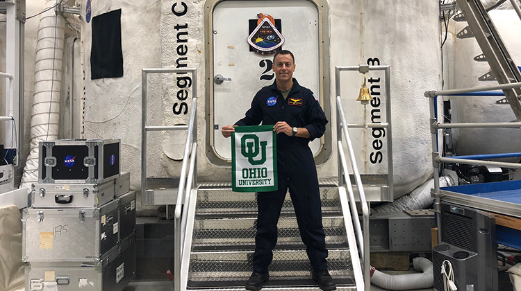 Bob Ferguson, BSME ’98, displays a little Bobcat pride outside of NASA’s Human Exploration Research Analog (HERA) habitat, a 636-square-foot mock spacecraft that the Ohio University graduate was confined to for 45 days as part of a NASA HERA research expedition.