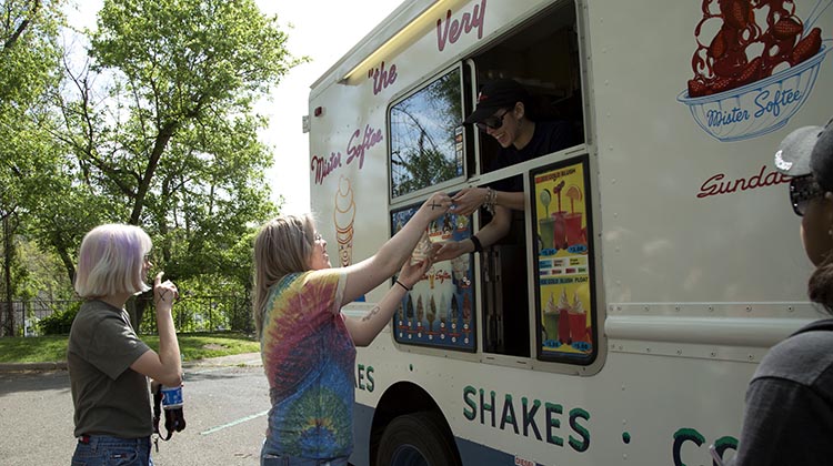 Two seniors receive ice cream cones from a food truck