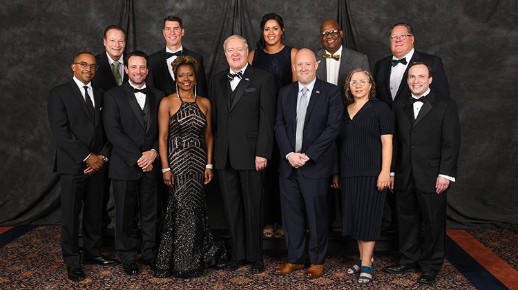 Ohio University President M. Duane Nellis (front center) is pictured with the 2019 Alumni Awards recipients. They are (front, from left) Abdul Williams, BSC ’94; Ryan Kyes, BBA ’02, MBA ’03; Mona Miliner, BSH ’92, MHA ’94; Kyle Kondik, BSJ ’06; Elizabeth Campbell, MFA ’97; Jeffery Baran, BA ’98, MA ’98; (back, from left) Garry Hunter on behalf of his brother, Larry Hunter, BSED ’71, MED ’73; retired Brig. Gen. Mark Arnold, BSISE ’82; Julia Winkfield Stover, BSRS ’06; Anthony Webb, BSC ’76; and William Axline, BBA ’71. 