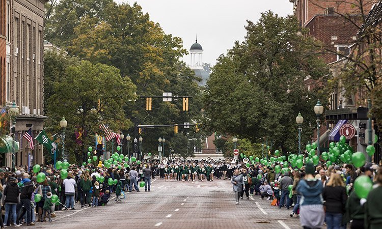 Court Street is lined with green balloons and Bobcat spirit as OHIO’s Marching 110 makes its way along the bricks of Athens during the 2018 Homecoming Parade.
