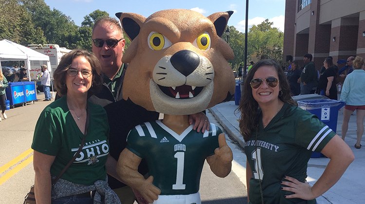 Legacy Scholarship recipient Molly Carrier and her parents, Les and Heather Carrier, both BBA '92, pose with Rufus. 