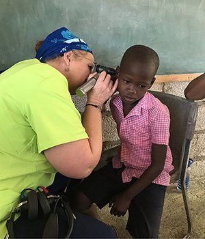 Audiologist Vanessa Lee, MAHSS ’95, examines the ears of a Haitian boy during a trip to the country with Mission Possible, an Ohio-based Christian nonprofit. 