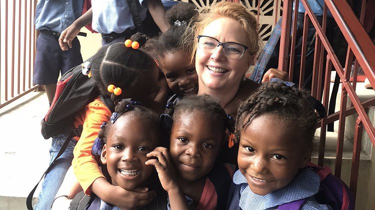 Audiologist Vanessa Lee, MAHSS ’95, is pictured with just a few of the hundreds of Haitian schoolchildren she has provided hearing screenings to during three trips to the Caribbean nation. 