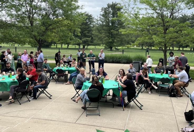 Members of the Division of Student Affairs sit outside at tables during the awards event