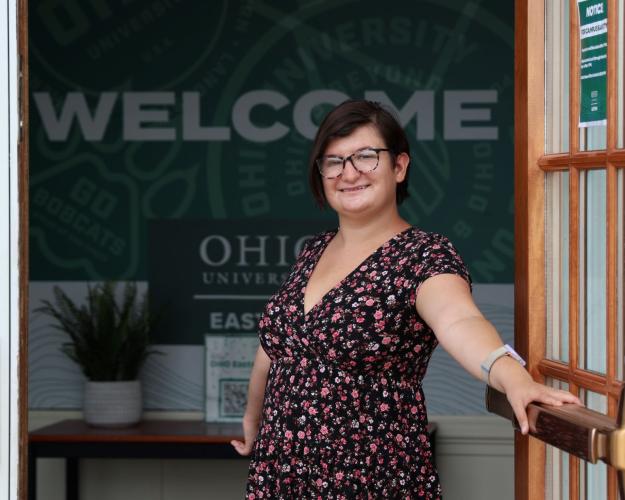 Women with short dark hair standing in front of a welcome sign