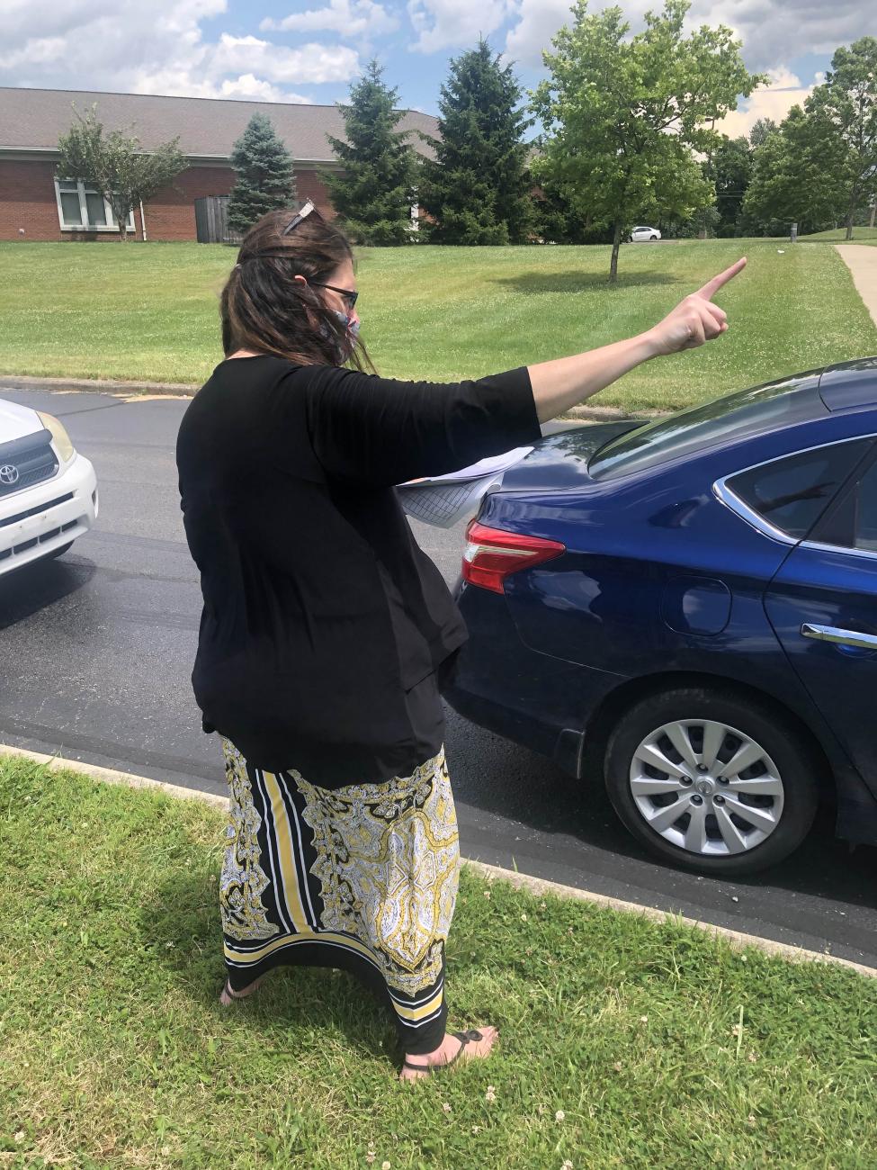 A woman directs traffic at the food distribution.