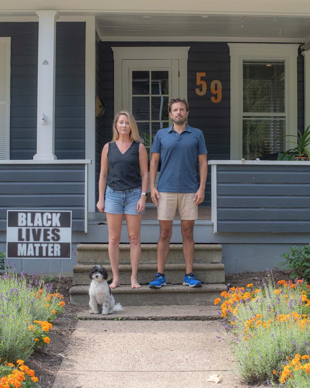 The Gabler family standing on their front porch with their yard sign