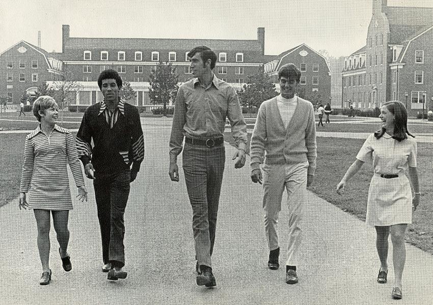 Ohio University Men’s Basketball players (from left) Tom Corde, Craig Love and Bob Howell are seen walking on West Green with two of the University’s cheerleaders.