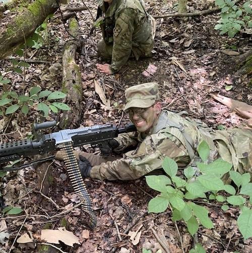 Cadet lays on the ground with his gun