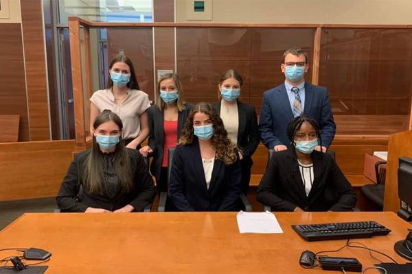 Student group pose for a picture in the courtroom