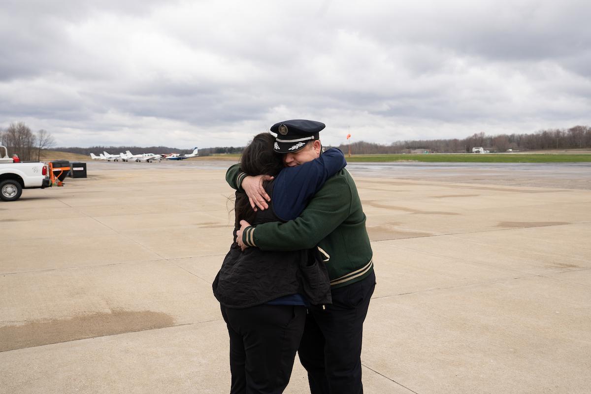 OHIO grad and pilot Dan Sneddon is shown hugging a member of the OHIO community after landing a Republic Airways jet at the Gordon K. Bush Ohio University Airport.  