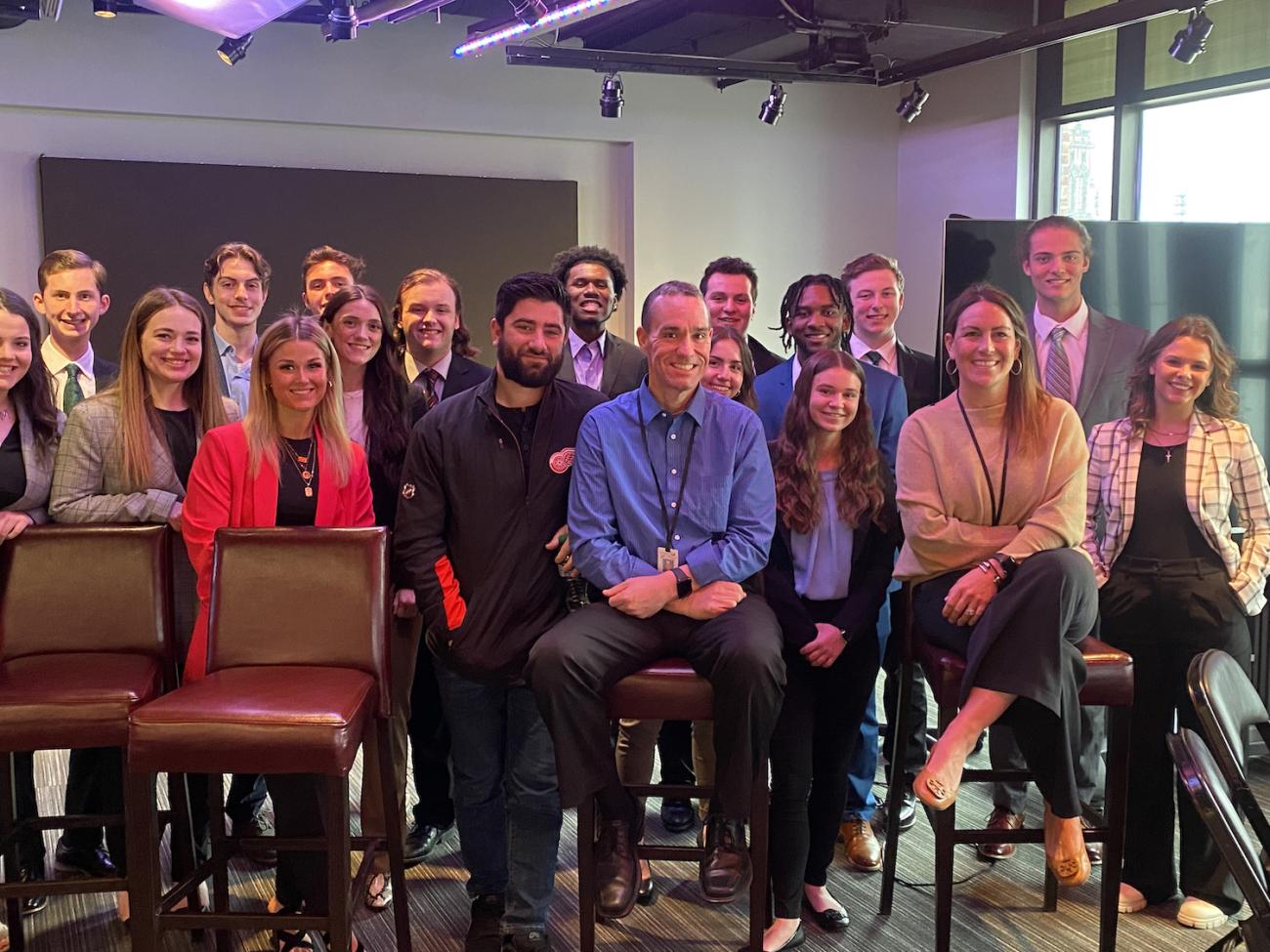 A group of Ohio University students stand together for a group photo behind three adults