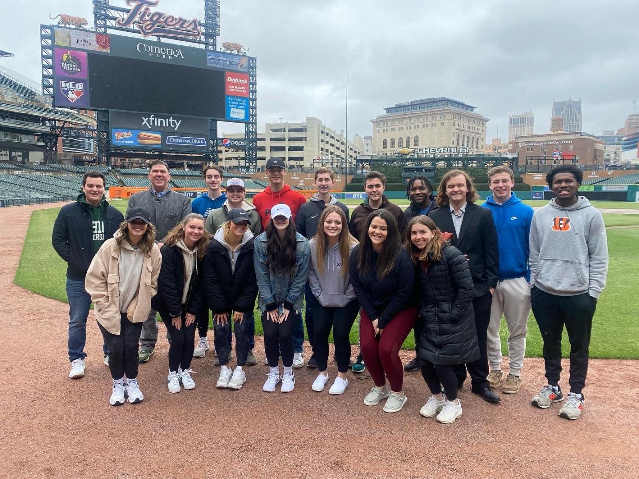 A group of Ohio University students standing together on a baseball field