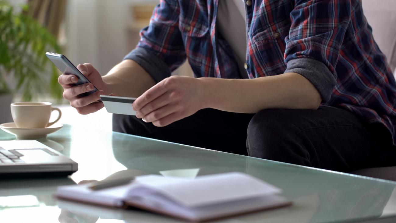 Ohio University student using their phone and OHIO ID