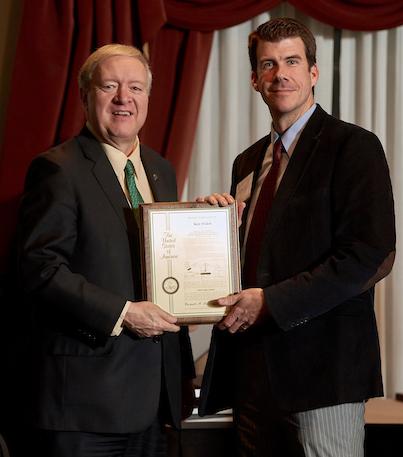 Duane Nellis and Kenneth Walsh holding an award