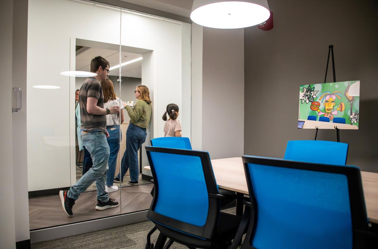 OHIO students are show standing outside of a meeting room during the grand opening celebration for The Den