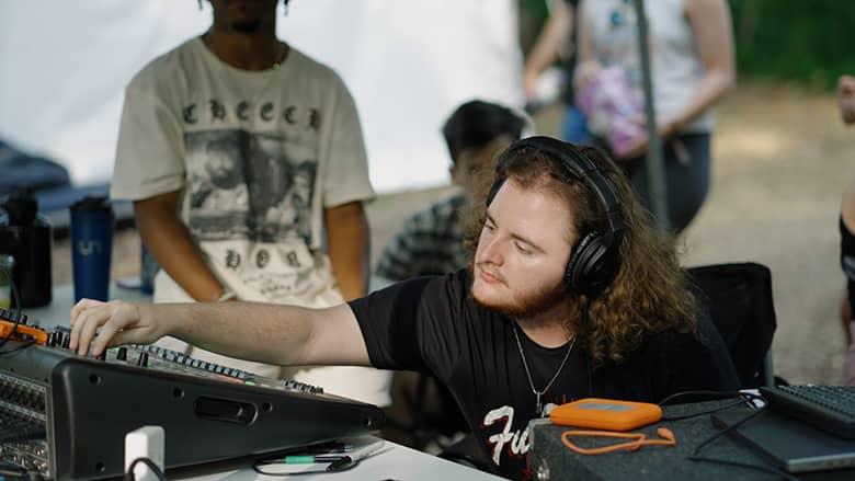 OHIO Alumnus Nathan Cain mixes audio for the Creekside Stage.