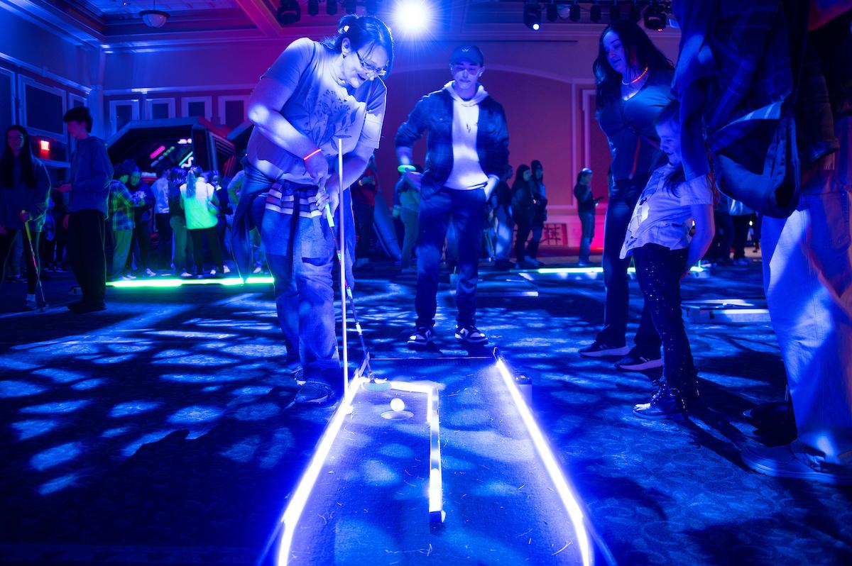 OHIO students and their siblings play lit up miniature golf at the GLOHIO event in Baker University Center.