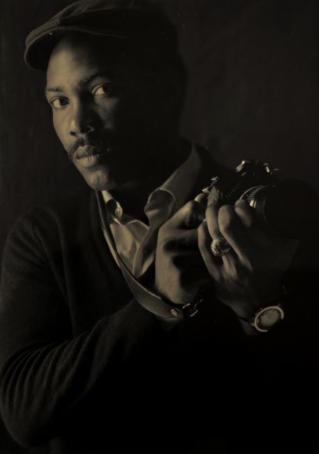OHIO alumnus Milt Brown, photographed in the 1980s holding a camera and wearing a hat