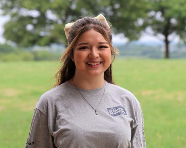 Young female with brown hair, wearing grey t-shirt