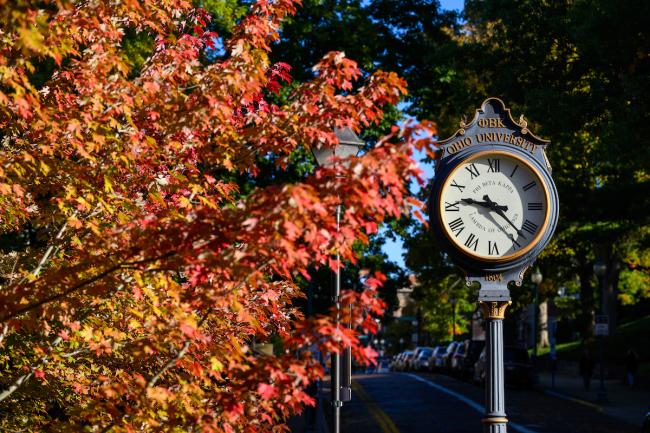 Colorful fall leaves surround a clock on OHIO's Athens campus