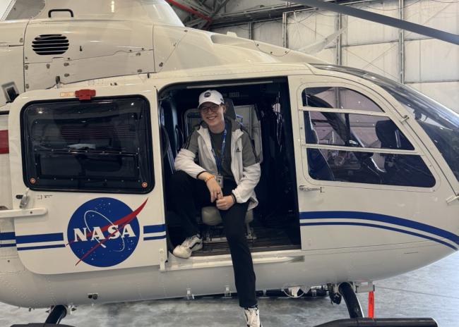 William Hamilton poses in a helicopter with a NASA logo on its side