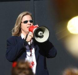 Natalie Royston directs the Cyclone Marching Band through a megaphone