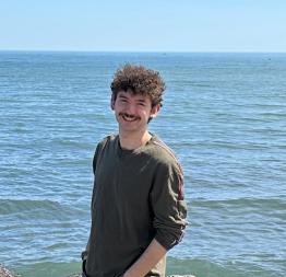 Joshua Irwin, smiling with a body of water behind him