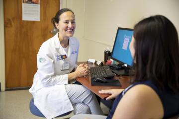 A doctor and student meet at Campus Care.