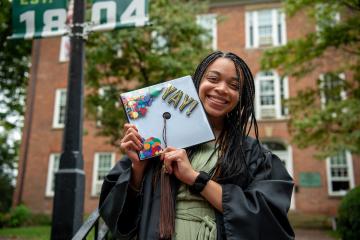 A graduate poses with her cap that reads 