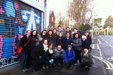 Group of students pose for a picture along the road