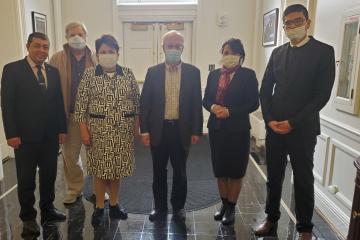 Six people stand together in a hallway with masks on for a picture