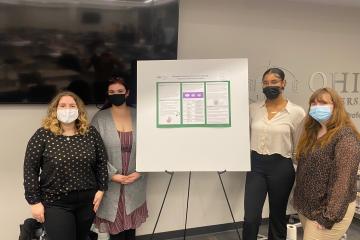 OHIO students stand by a poster board