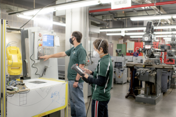 ETM professor and student working with a machine