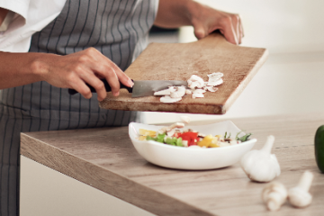 A photo of an individual preparing a meal