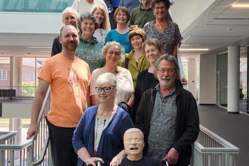 Standardized patients for the Heritage College of Osteopathic Medicine pose in Heritage Hall