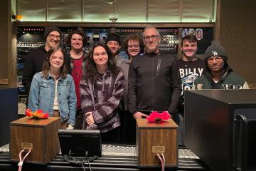 A group of students pose for a photo in a music studio